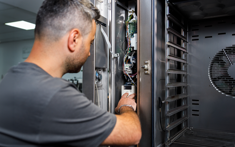 Servicetechniker repariert ein geöffnetes Großküchengerät